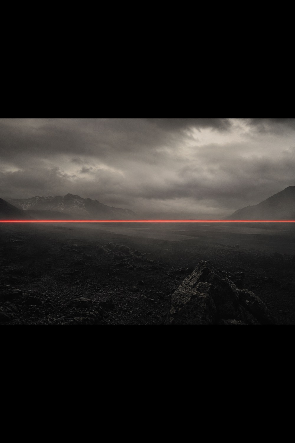 A red beam of light crossing a dark landscape